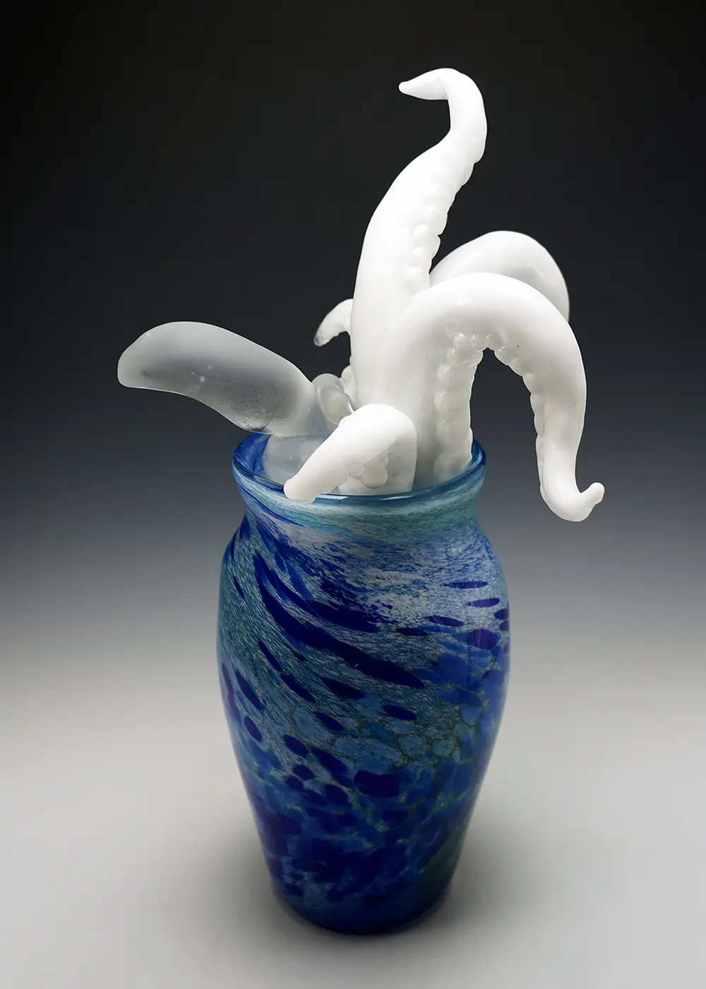 蛸壺から触腕を大きく伸ばしているようなガラス製の作品がある。蛸は頭と触腕５本を壺から出していて、他の部位は壺の中に収まっている。壺の背は高く、横幅は狭い古来から使われてきた陶器製の蛸壺をイメージしている。触腕は真っ白で頭は半透明となっており表面の質感が異なる。触腕には吸盤がついている。また、壺の部分は青や白、水色などの斑点模様が何色にも渡って構成されており、海のような雰囲気を醸し出している。この模様は左から右に捩れている。